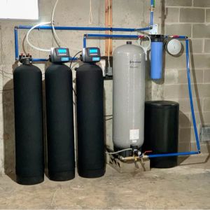 A multi stage whole home water filtration system installed in a home's basement